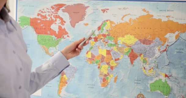 女性マネージャーは 観光会社の代理店で世界地図上の国を指します 地理教師は 教室の遅い動きに大きな可能性を持つ国を示しています — ストック動画