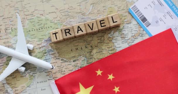 世界地图上的中国飞机和机票 通过旅行社环球旅行的概念 中国国旗靠近刻有 字样的木块 — 图库视频影像