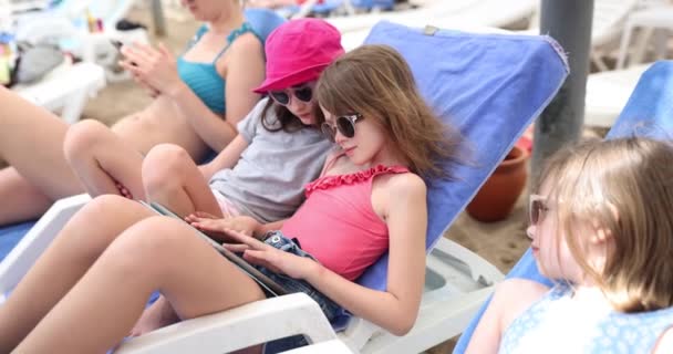 Hermanas Adolescentes Yacen Tumbonas Jugando Tableta Cerca Madre Tecnología Relajación — Vídeo de stock