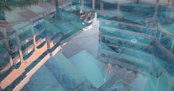 日落时带蓝色瓷砖游泳池水中酒店建筑的倒影 游泳慢运动度假区及地点的概念 — 图库视频影像