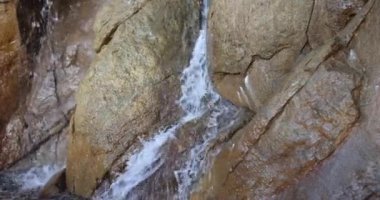 Doğal temiz su kaynağı. İskoçya 'daki Rocky Şelalesi. Güneşli yaz gününde ağır çekimde akan suyun resimli görüntüsü.