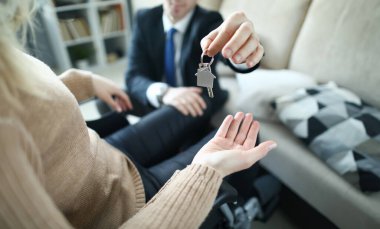 Müşteri ve emlakçıya yakın çekim. Ajan, kira sözleşmesinin imzalanmasından sonra apartmanın yeni sahibine evin anahtarlarını veriyor. Emlak konsepti. Toplumda engelli insanların adaptasyonu