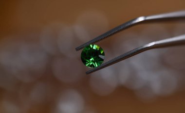 Lüks zümrüt kristal değerli taşın yakın görüntüsü. Cilalanmış yeşil elmasın makro görüntüsü. En değerli güzellik. Kusursuz, zekice kesilmiş ve lüks mücevher konsepti.