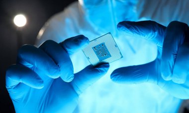 Detaylı mikroçipi tutan eldivenli eller. Özel üniformalı adam mikroişlemci çipi gösteriyor. Üretim teknolojisi Hitech. Mikro işlemci elektronik teçhizatı tamir et.