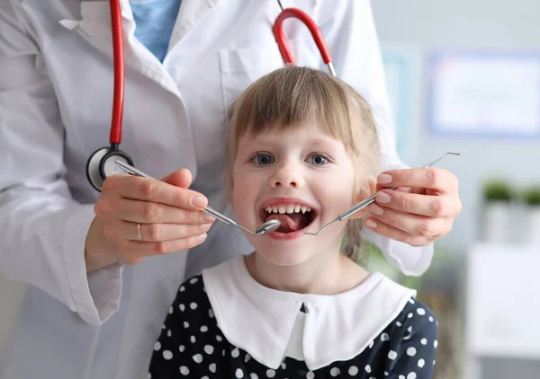 小さな女の子歯医者に歯を見ることを恐れていません 歯科医の予言的な検査の子供 高品質の歯科治療 医師は口腔を検査し 結果を評価します前の治療 — ストック写真