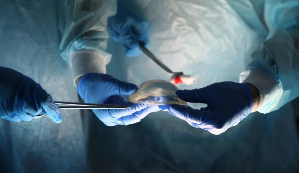 Cirujanos Sosteniendo Instrumentos Implantes Mamarios Cirujano Plástico Ofrece Implantes Mamarios —  Fotos de Stock