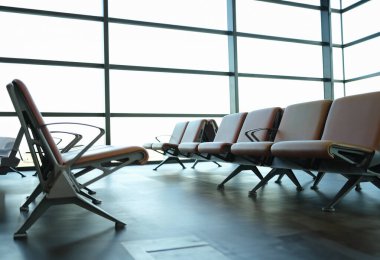 Modern airport waiting area with leather seats. Vacation and travel concept