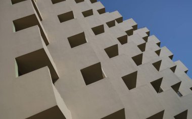 Building profile with concrete beams against sky. Residential complex with balconies