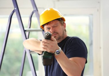 Elektrikli matkap closeup kullanarak alt kollarından. El ile iş DIY ilham geliştirme tamir dükkanı sarı kask sanayi başlangıç fikir endüstriyel eğitim meslek kariyer kavramı