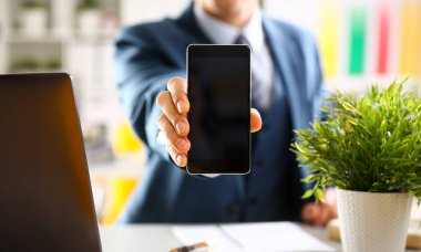 Takım elbiseli erkek kolunu göster kamera telefon ekran ekran portre. Haber mania göndermek sms okumak sohbet bağımlısı kullanın meslektaşım paylaşmak blog cıvıldamak web uygulama arama elektronik banka modern yaşam tarzı iş planı
