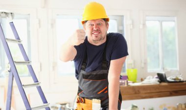Sarı kask poz içinde komik işçi gülümseyerek. El ile iş işyeri DIY ilham geliştirme tamir dükkanı baret sanayi başlangıç fikir endüstriyel enerji meslek kızgın kavramı