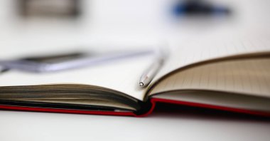 Gümüş kalem yatan defter sayfası closeup office worktable dizüstü pc ile açıldı. Müfettiş işgal öğrenci sınav veya kariyer strateji kişisel eğitim sahası imza konsepti için