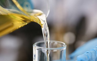 Motor yağı otomatik vites ve hidrolik yükseltici kimya test tüp elinde üretir koruyucu eldiven erkek el ele tutuşur