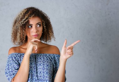 Gri bir arka plan üzerinde siyah bir kadın Puan bir parmak havada girmek için yazabilirsiniz bir yazıt