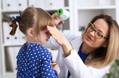 Doktor resepsiyonda küçük çocuk. Çocuk doktoru çok hızlı bir şekilde bir kızılötesi lazer termometre artış yüksek sıcaklık ölçer