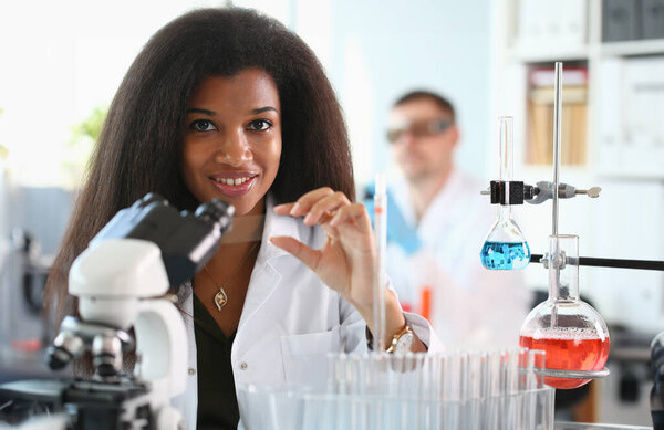 A female chemist holds test tube of glass in his hand overflows liquid solution potassium. Permanganate conducts an analysis reaction takes various versions reagents using chemical manufacturing.