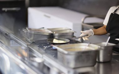 Aşçı mutfakta tavada omlet hazırlar. Kafelerde ve restoranlarda yemek pişirme konsepti