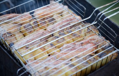 Yangının üstünde kızarmış domuz ve patates var. Ev yemeği kebabı konsepti