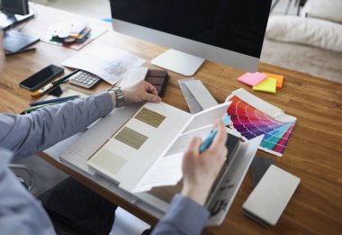 Erkek tasarımcı ev için döşeme kalıplarını seçer. Ahşap kavramından örnekler