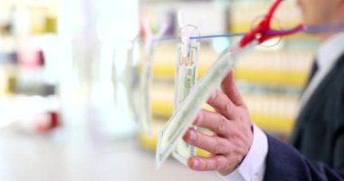 Erkek işadamı ve Amerikan doları ipte, mandalları da yakın planda. İş dünyasında kara para aklama ve yasadışı mali gelir