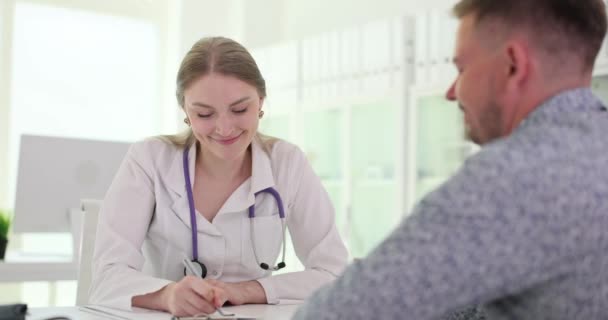 Lächelnder Arzt Schreibt Gutes Testergebnis Auf Männliche Patienten Diskutieren Über — Stockvideo