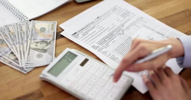 税金申告書1040を記入し 計算機を数えるビジネス女性 財務書類 税務時間の登録について — ストック動画