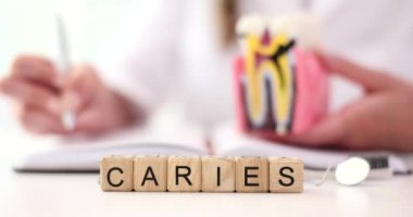 Diş hekimi hastanın tıbbi geçmişini ve kelime kayıtlarını dolduruyor. Caries, diş dokusunda meydana gelen ağır patolojik süreçteki karmaşık bir işlemdir.