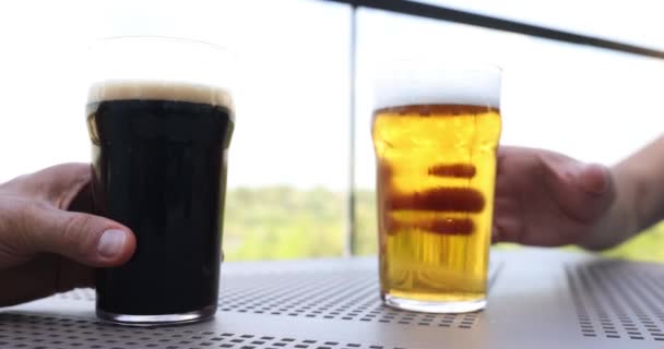 パブでビールトーストを飲む人 グラスの中の暗くて軽いおいしいビール — ストック動画