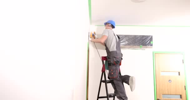 清除灰尘和粗糙的研磨墙壁 工人们使用天花板和墙面砂磨机 — 图库视频影像