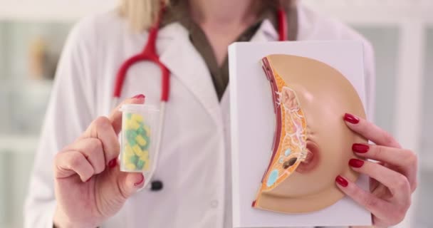 人工乳母モデルと予防のための丸薬のプラスチックボトルを保持する女性医師 がん患者のスローモーションをサポートする専門医 — ストック動画