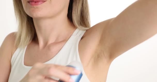 白いTシャツの若い女性は 汗臭を防ぐために消臭剤を使用しています 化粧品は 脇の汗を除去するために使用しました 衛生とセルフケアのスローモーション — ストック動画