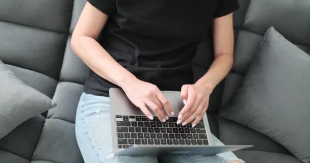Wanita Dengan Celana Jeans Robek Duduk Sofa Hitam Dengan Laptop — Stok Video