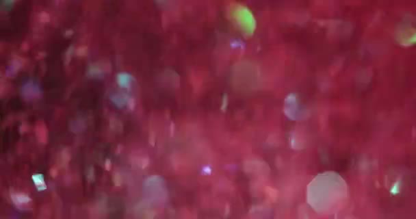 パーティーやお祝いのための軽い赤とピンクの光沢のあるホイルの装飾 明るい輝くホイルの概念が付いている黒い背景の壁紙 — ストック動画