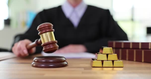 裁判所のテーブルで木製タケルをノックする女性裁判官 汚職の兆候として光沢のある金塊の積み重ね 法執行機関のコンセプトの遅い動きにおける詐欺 — ストック動画