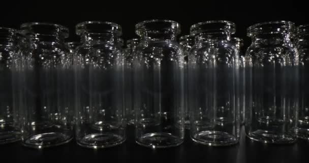 Leere Glasflaschen Für Impfstoffe Reihenweise Auf Schwarzer Oberfläche Dunklen Raum — Stockvideo