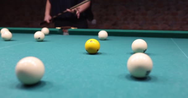 プレイヤーは ビリヤードプールテーブルのポケットにゴールをプッシュするために黄色いボールを撮影します 楽しいビリヤード カジノ エンターテイメント ナイトライフ コンセプト スローモーション — ストック動画