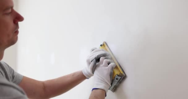 Handwerker Mit Schutzhelm Poliert Wand Leerer Wohnung Bauunternehmer Kratzt Unebene — Stockvideo