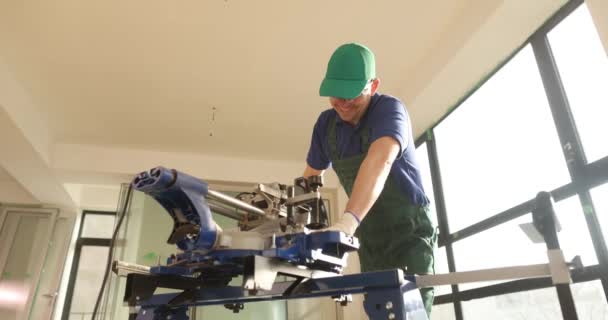 改装工房でチェーンソーとパーケットボードを切断する大工 ダストスローモーションで木材を切断する作業服の労働者を構築する — ストック動画