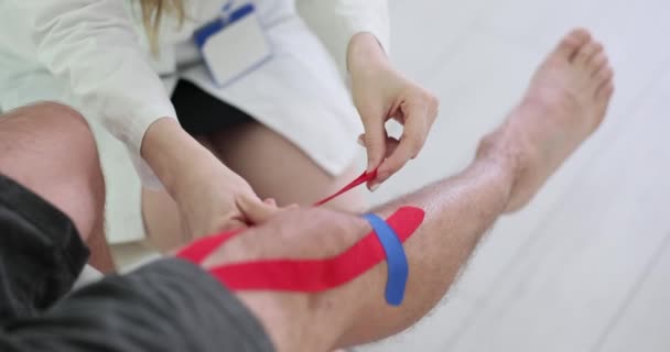 Physiotherapeut Klebt Kinesiotape Auf Das Knie Des Patienten Meniskusverletzung Bei — Stockvideo