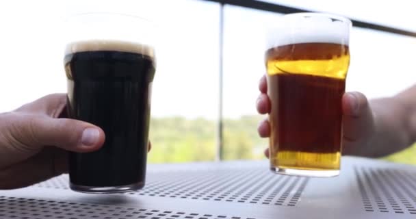 人们和酒吧里的啤酒吐司交朋友 玻璃杯中的黑啤酒和淡啤酒 — 图库视频影像