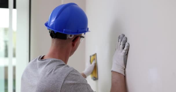 人是砂纸专业建筑工人戴着面具和保护硬帽的砂墙 室内建筑工地 — 图库视频影像