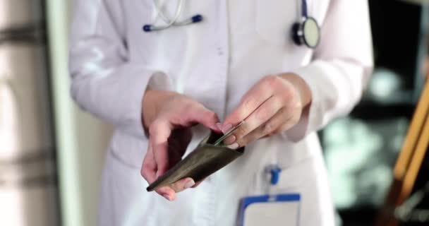 女医生在钱包特写中计算钱 医务工作者的薪金和金融危机 — 图库视频影像