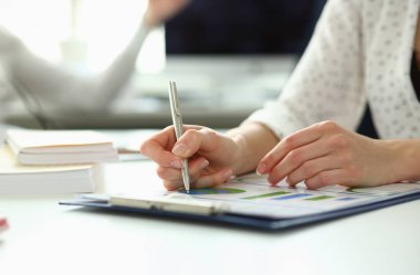 Yakın plan kadın kolları kağıt klasörüne bir şeyler yazıyor. Önemli bir sözleşmesi var. Şirket kârının gelirini oldukça artırabilir. Şirket toplantısı konsepti