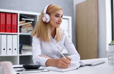 Güzel kız öğrencinin öğrenme ve müzik kulaklık ile. Kalem elini ve laptop monitör arıyor tutun