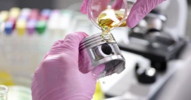 Bilimadamı araştırmacı laboratuvar kapanışında arabanın pistonuna motor yağı döküyor. Yağlayıcı testi