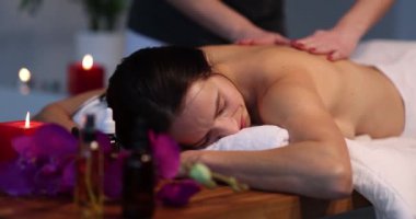 Acosmetology Spa 'da masörü olan bir kadının sırt masajı. Bayan müşteriyi rahatlatıyor. Kaplıca salonundaki masözle aromaterapi masaj hizmeti alıyor.