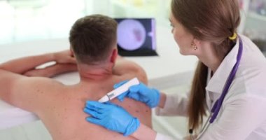 Benlerin dermatoskopisi, doktor hastaları muayene ediyor. Onkoloji dermatoloji kliniğinde tıbbi muayene