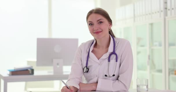 クリニックで笑顔のプロの女性医師セラピスト 医療サービスと保険について — ストック動画