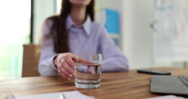 木のテーブルで飲むための水のグラスを保持する女性マネージャー 手の震えは原因 診断および処置を引き起こします — ストック動画