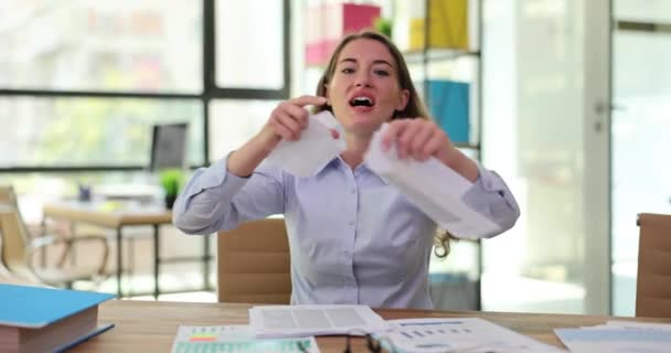 オフィスでデスクに座っている若い女性は仕事に怒り 顔に失望した表情で文書を涙で流している 職場でのネガティブな人間の感情 — ストック動画
